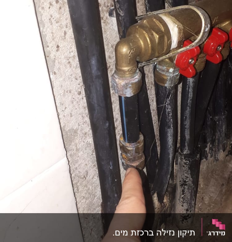 צינורות שחורים עם ברזים אדומים ואצבע מצביעה